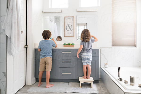 two kids brushing their teeth - good oral hygiene