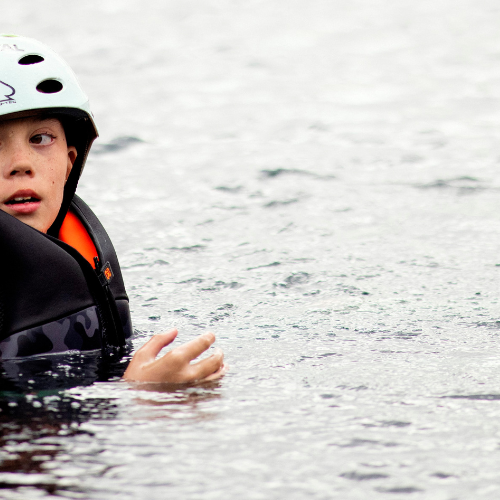 Kid floating in the water while wearing a CGA life vest